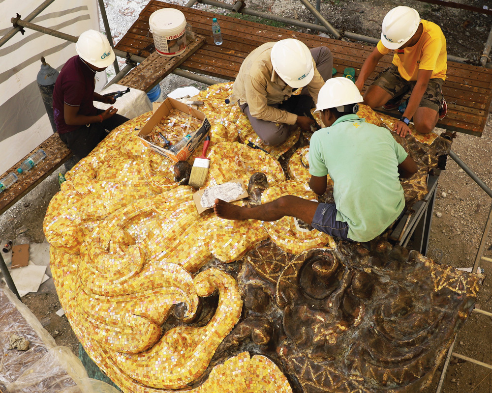 Warna emas mahkota dan badong Dewa Wisnu terbuat dari ribuan keping kaca mozaik