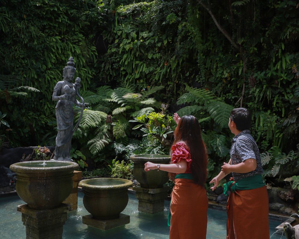 Melemparkan koin ke tengah kolam Dewi Laksmi Plaza Kura-Kura sembari mengucap harapan dan doa